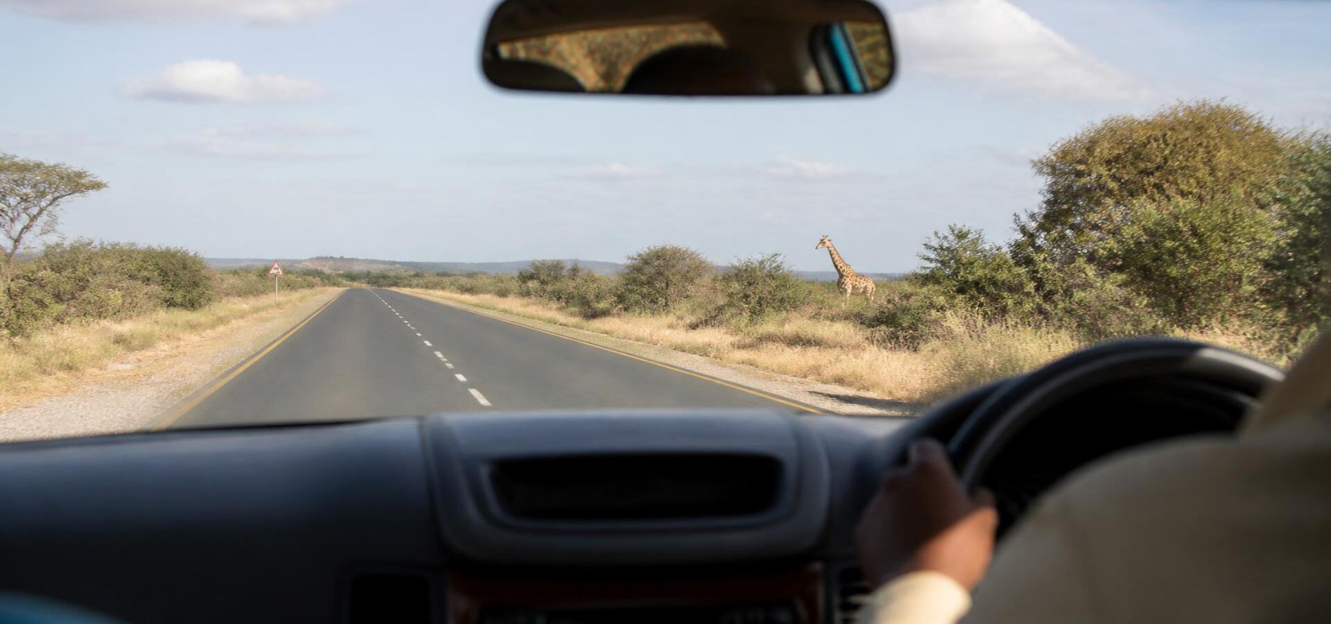 View from inside a vehicle cabin looking out at the road ahead